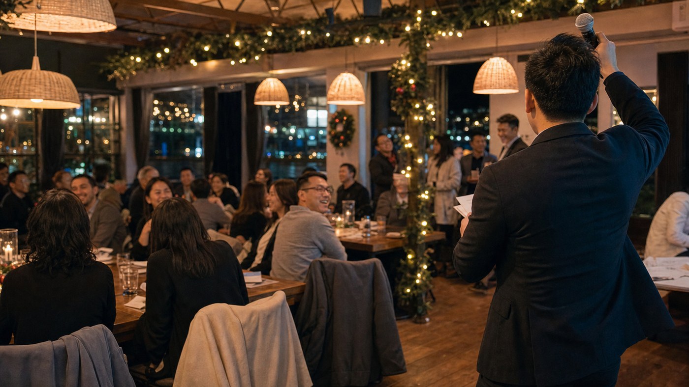 Nighttime Christmas in July party with an MC speaking to guests in warm venue light